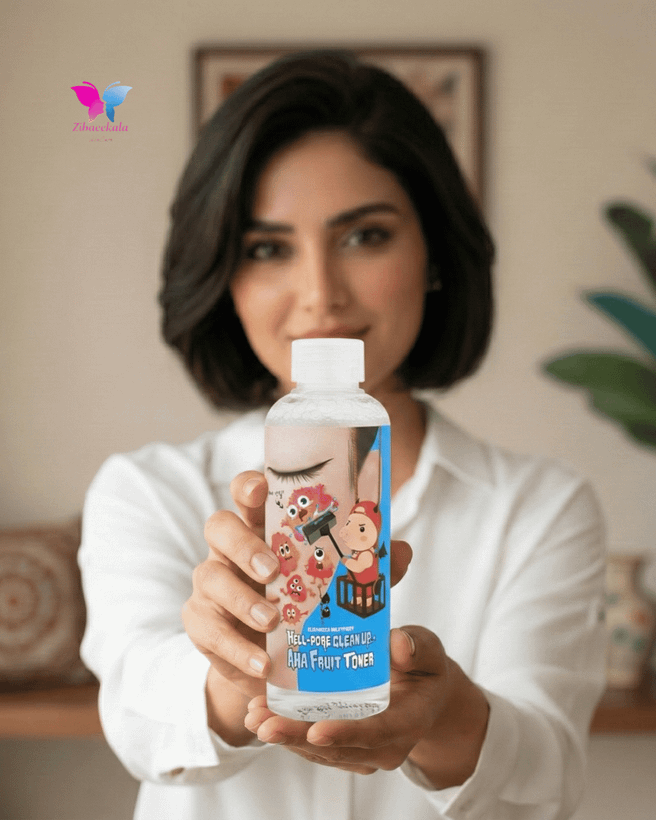 نمای نزدیک از بطری شفاف تونر پاککننده منافذ الیزاوکا با لیبل آبی کارتونی (طرح خوک) و نوشته AHA Fruit Toner.
